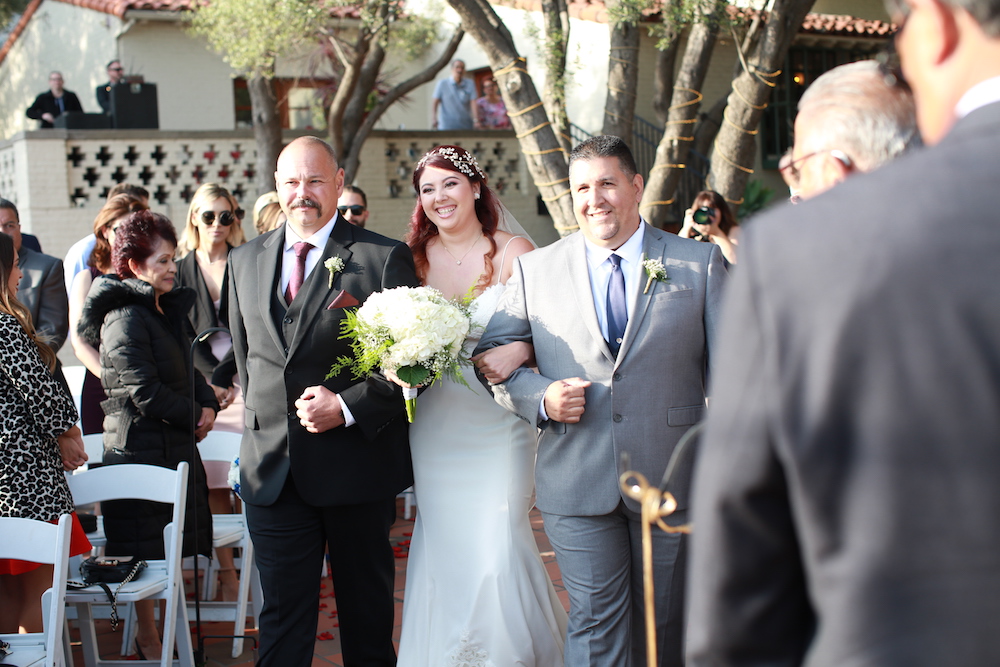 bride walking down the aisle with two men