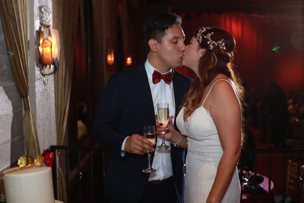 bride and groom kissing with champagne