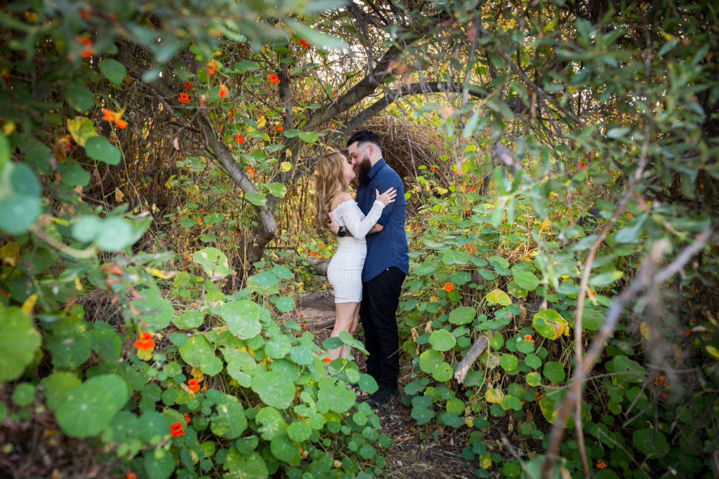 couple about to kiss in luch greenery
