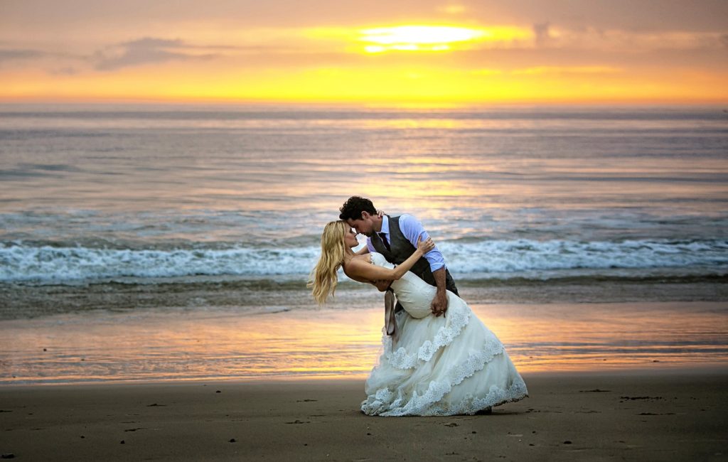 wedding couple dipping on the beach sunset