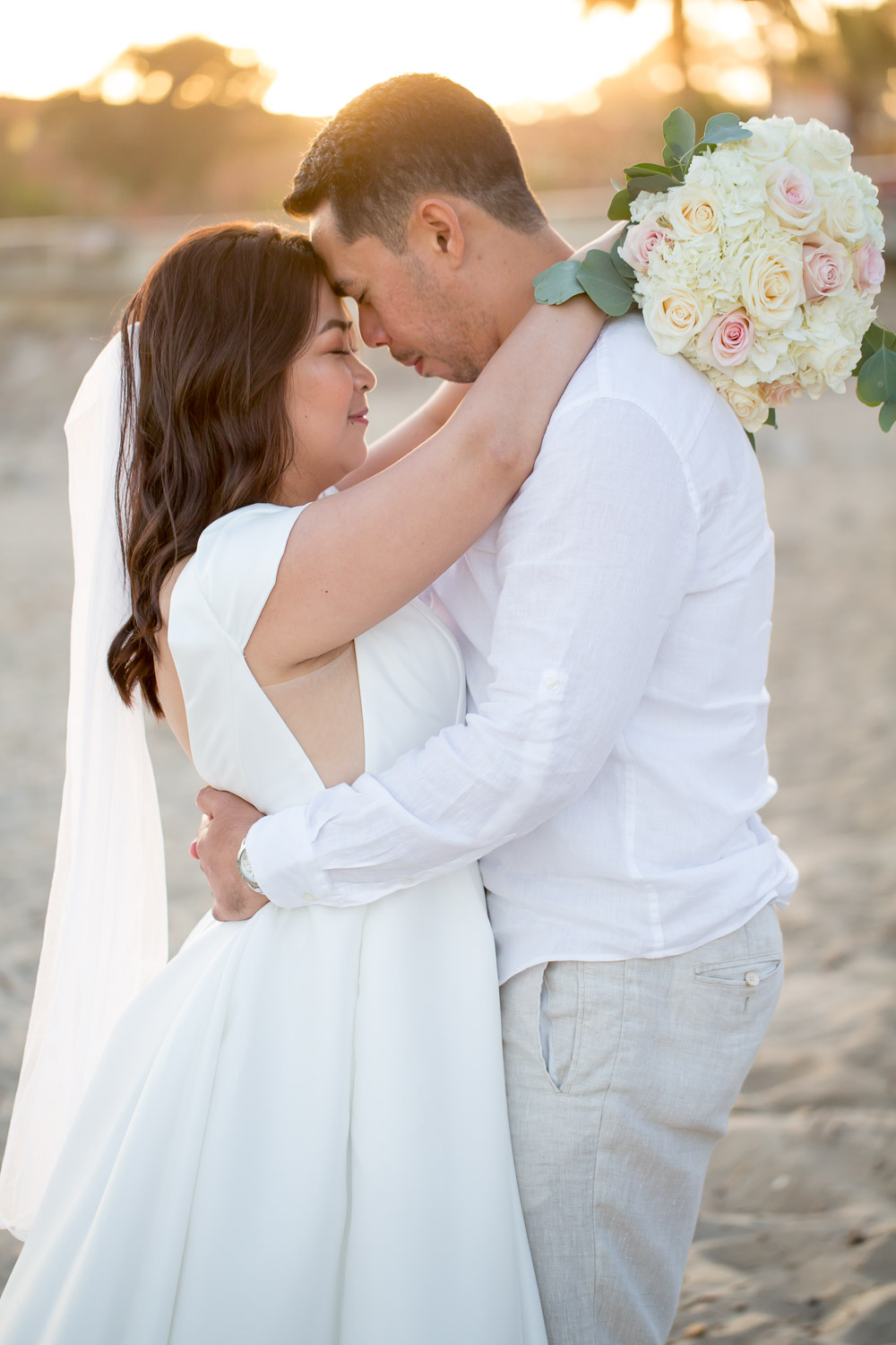 bride and groom on beach embracing