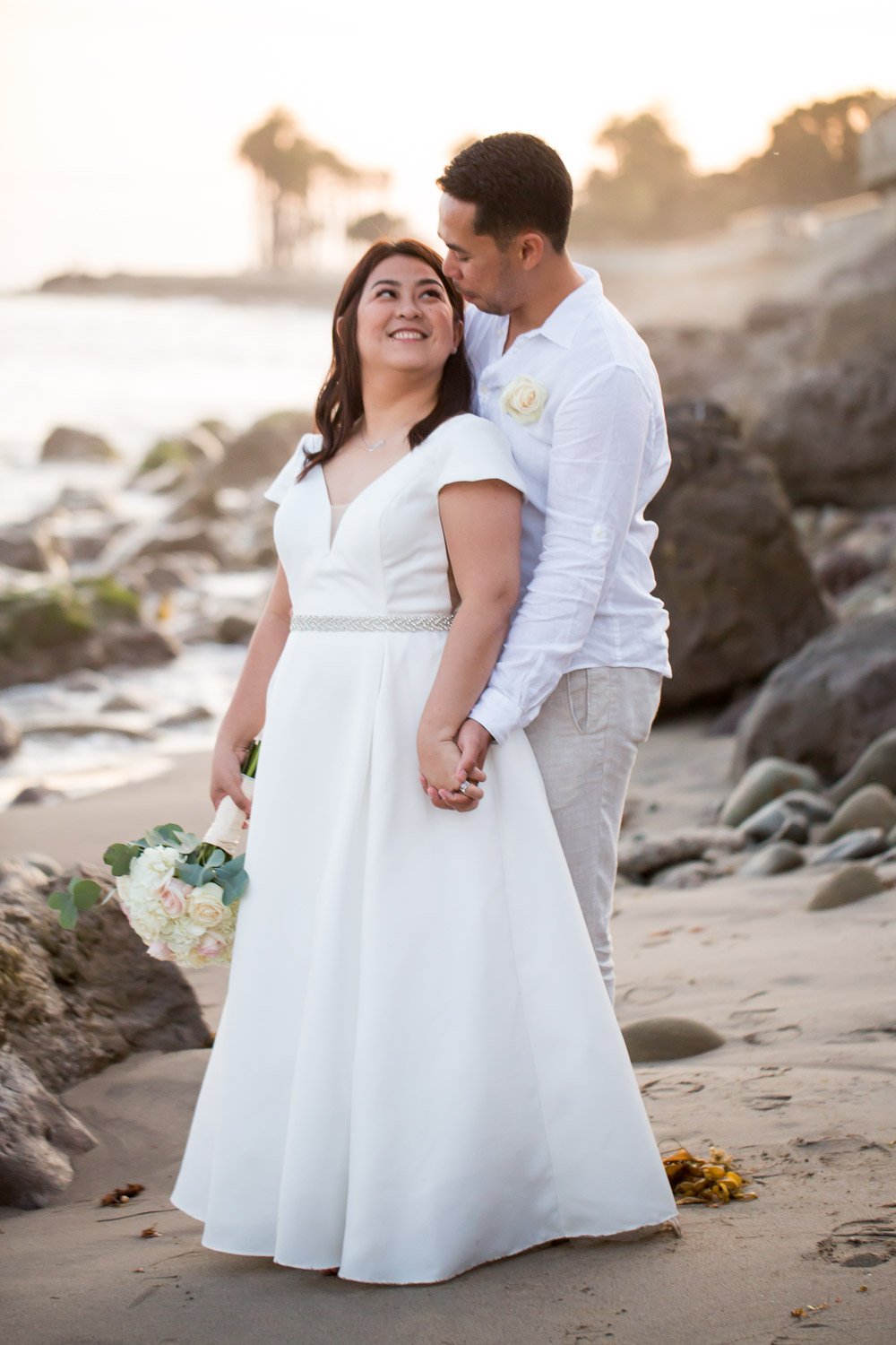bride and groom on rocky beach