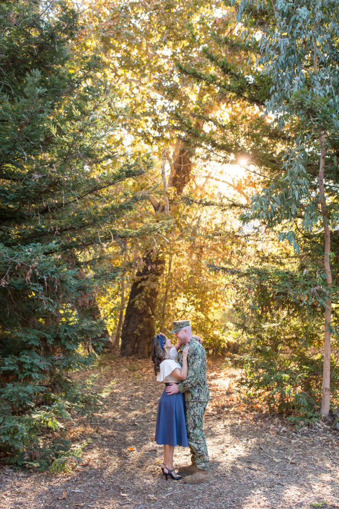 sailer and fiance standing in the forest