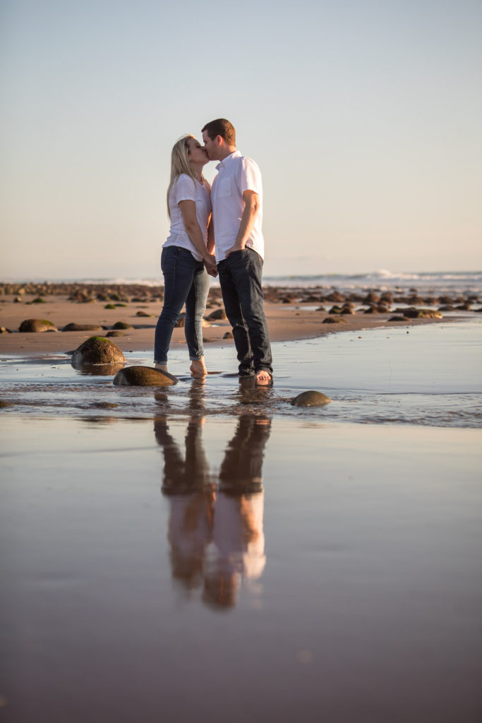 couple standing on the beach low tide