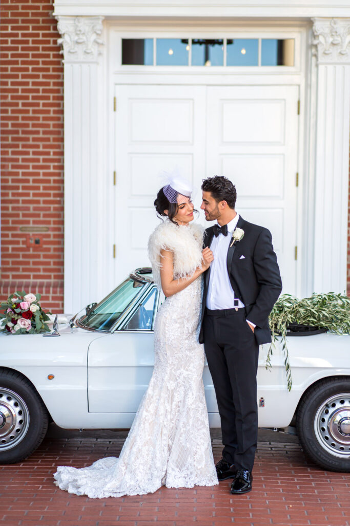 bride and groom in front of a car at sherwood country club