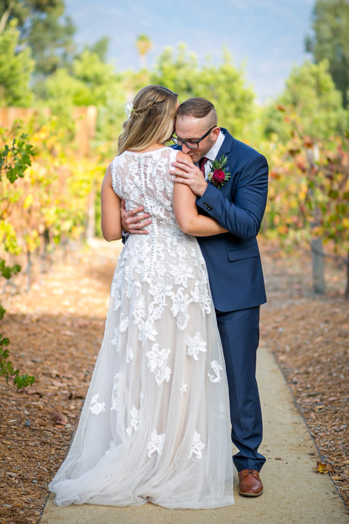 groom kissing brides shoulder at one of The 10 Best Vineyard Wedding Venues in California