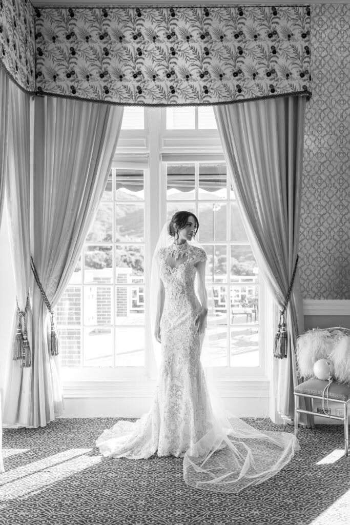 black and white portrait of bride by a large window