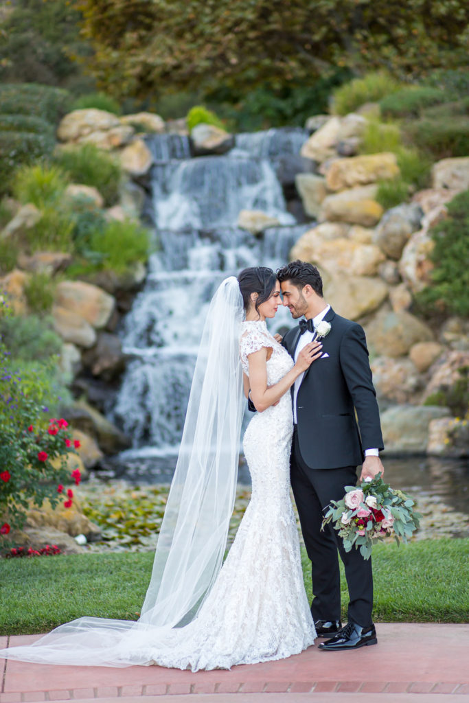 bride and groom in front of waterfall sherwood country club