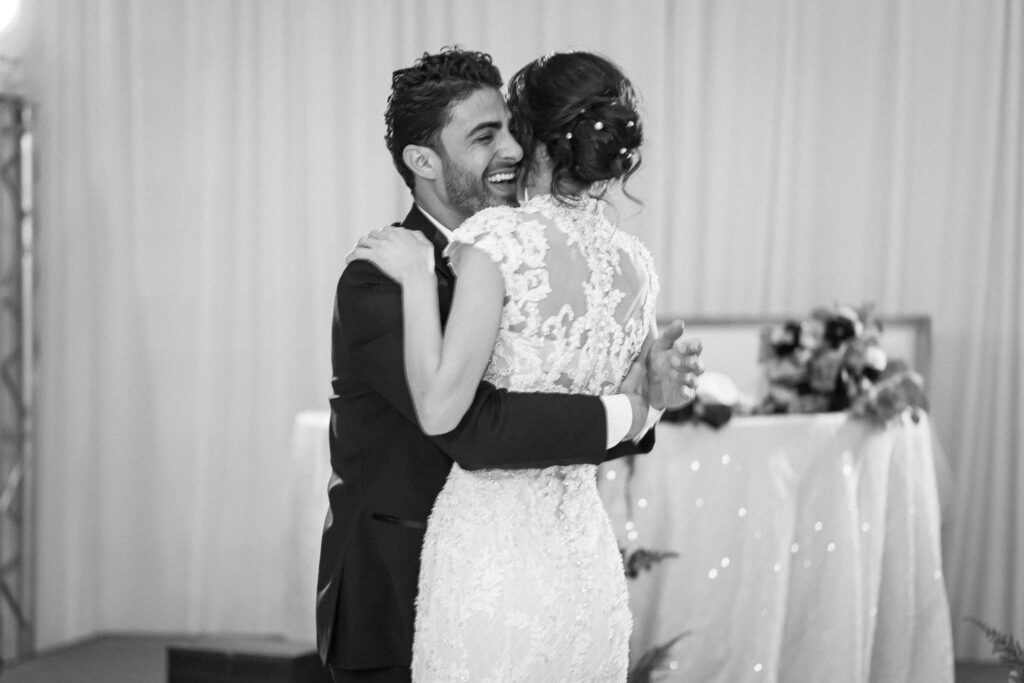 black and white portrait of bride and groom dancing