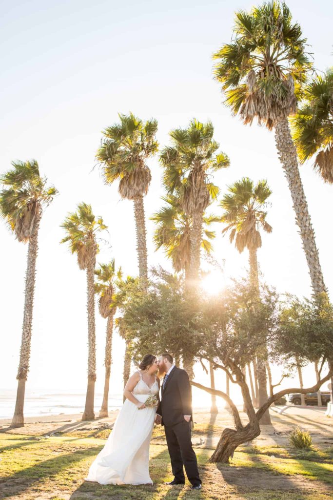 bride and groom by palm trees ventura beach