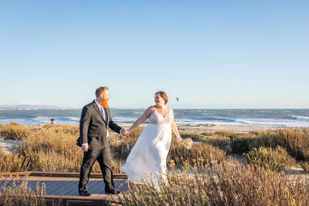 bride and groom walking on path ventura beach