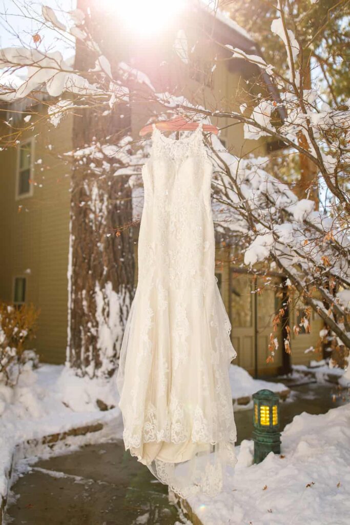 dress hanging in snowy trees lake tahoe wedding