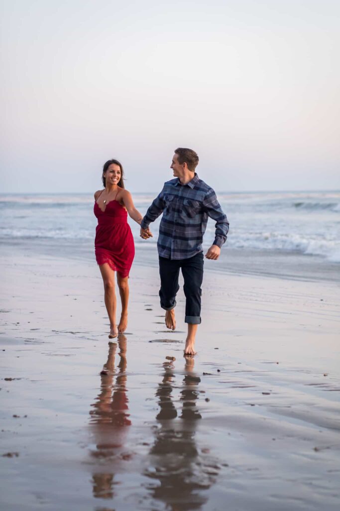 couple running together on the beach santa barbara engagement session