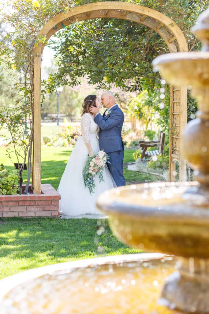 bride and groom behind a fountain at camarillo ranch