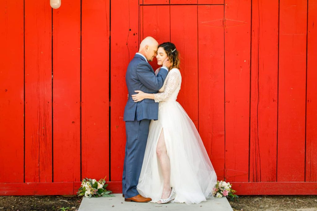 bride and groom in front of the red barn at camarillo ranch