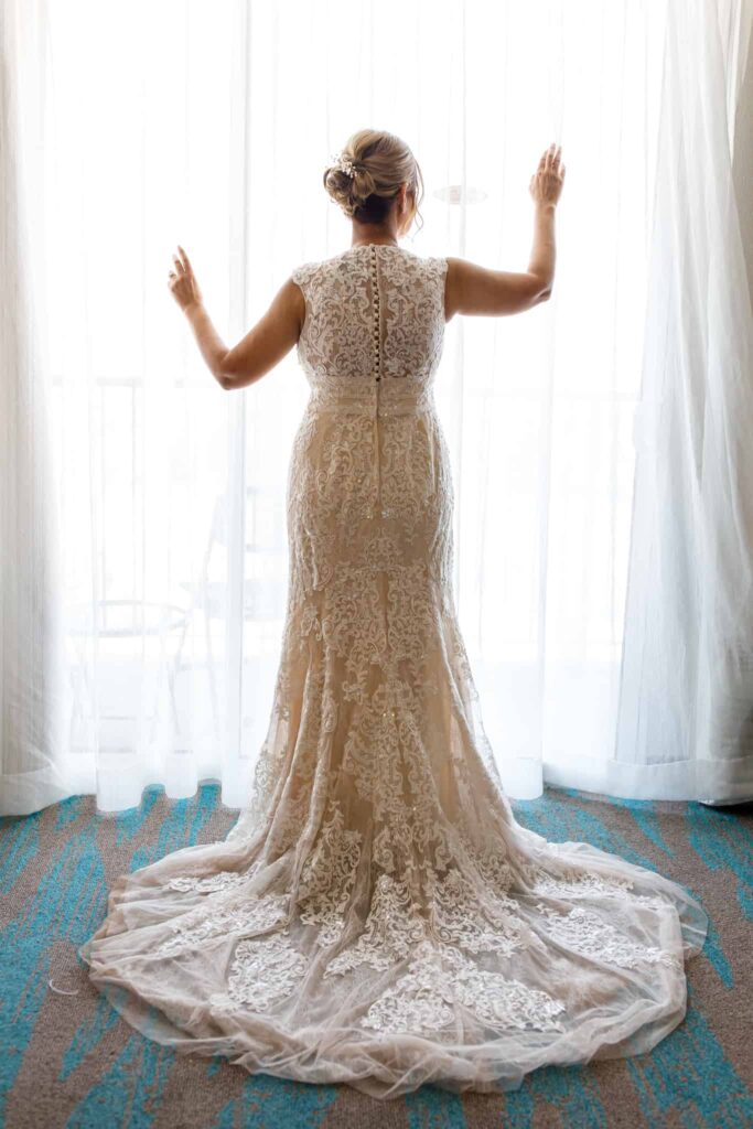 bride standing in the window in her gown