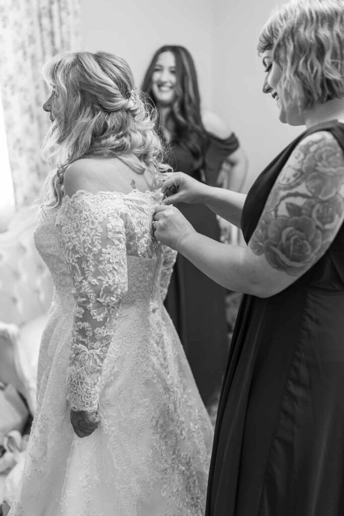 bride getting her gown buttoned