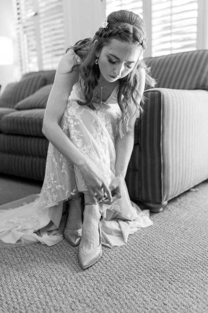 bride adjusting her shoes on her wedding day