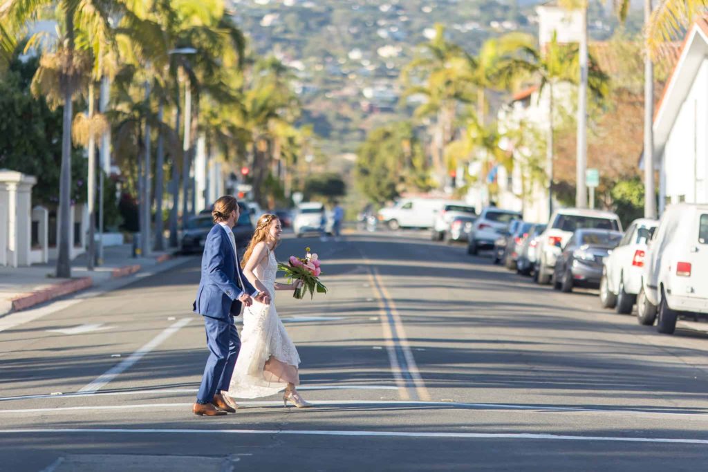 bride and groom crossing the street in santa barbara