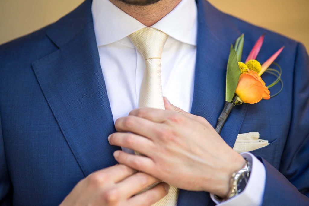 groom adjusting his tie on his wedding day