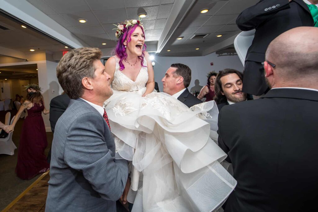 bride being lifted on a chair during reception