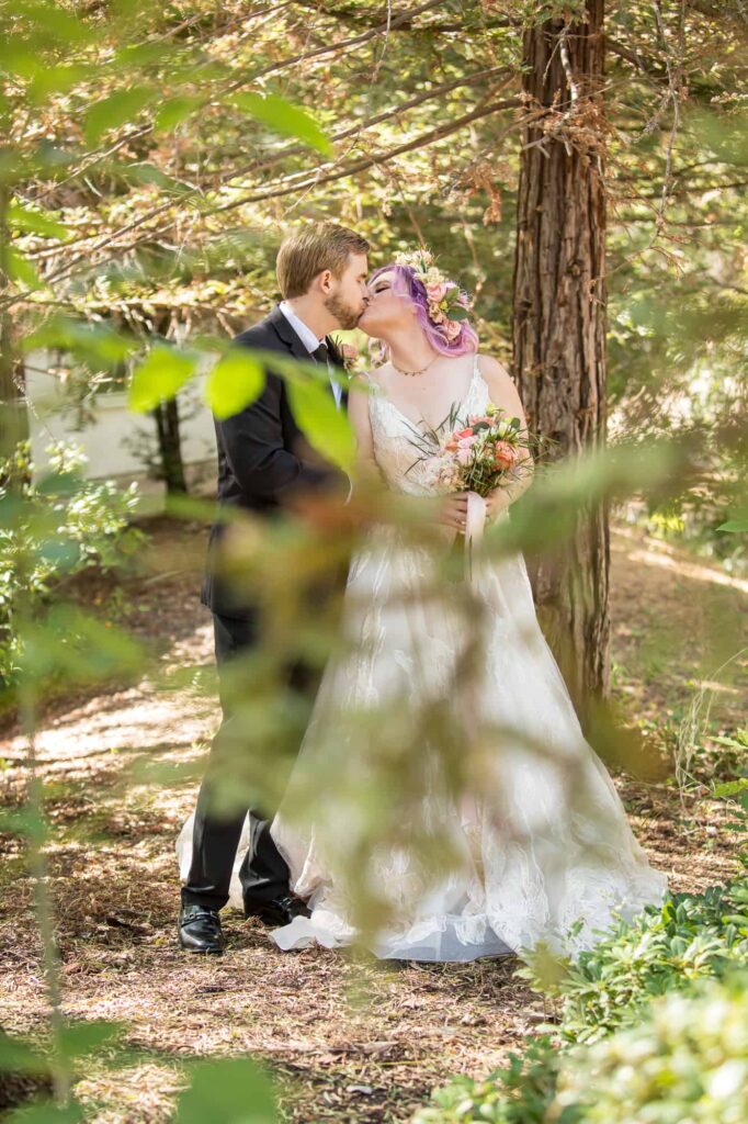 bride and groom kissing in a forest