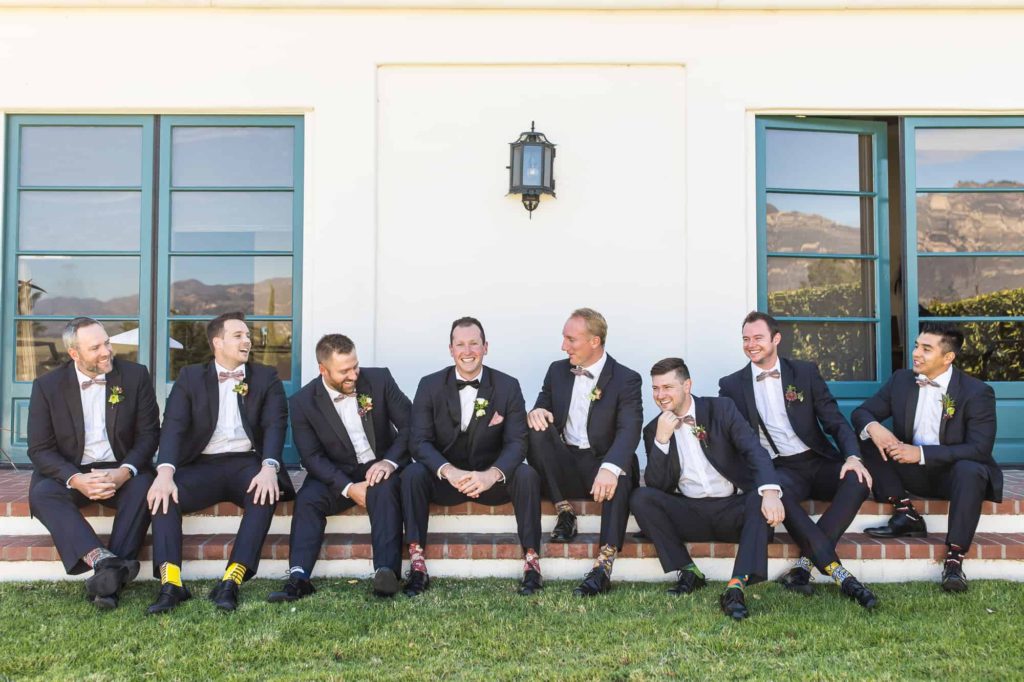 groom and groomsmen sitting and laughing together