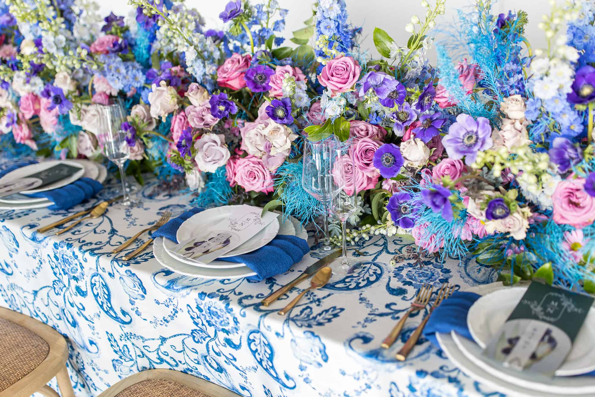 reception tablescape with blue floral table cloth and bright flowers by one of the Best Wedding Vendors in Santa Barbara