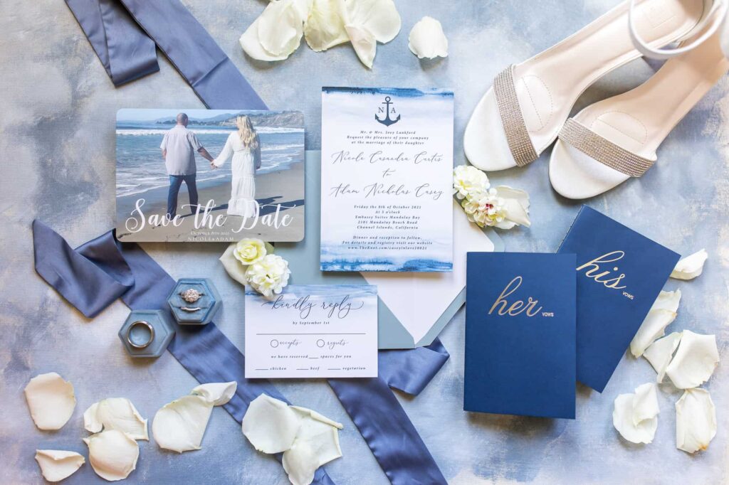 wedding invitation flat lay with blue his and her vow books