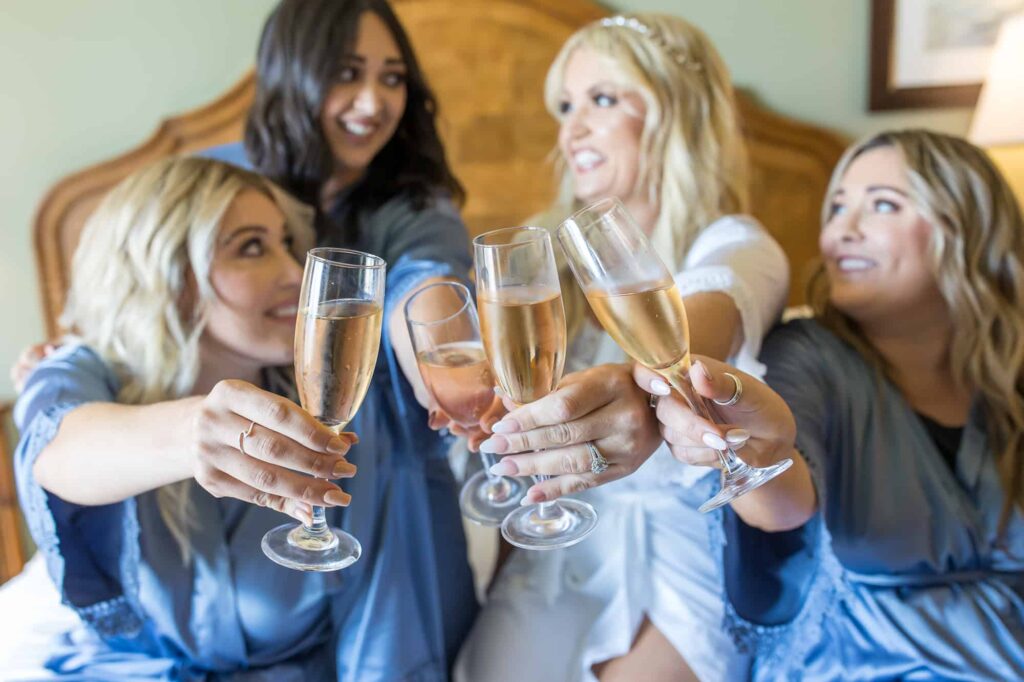 bride and bridesmaids holding champagne glasses