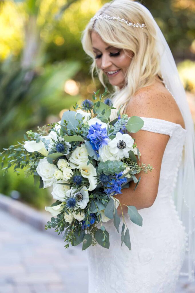bride holding a large blue floral bouquet