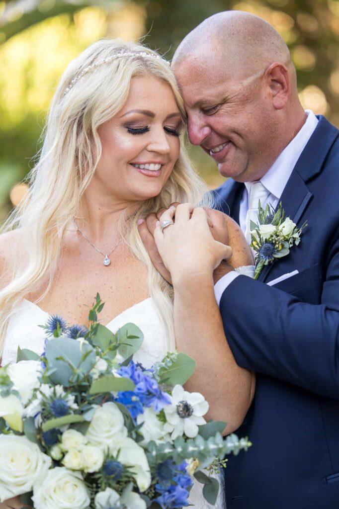 bride and groom with blue flowers and navy suit