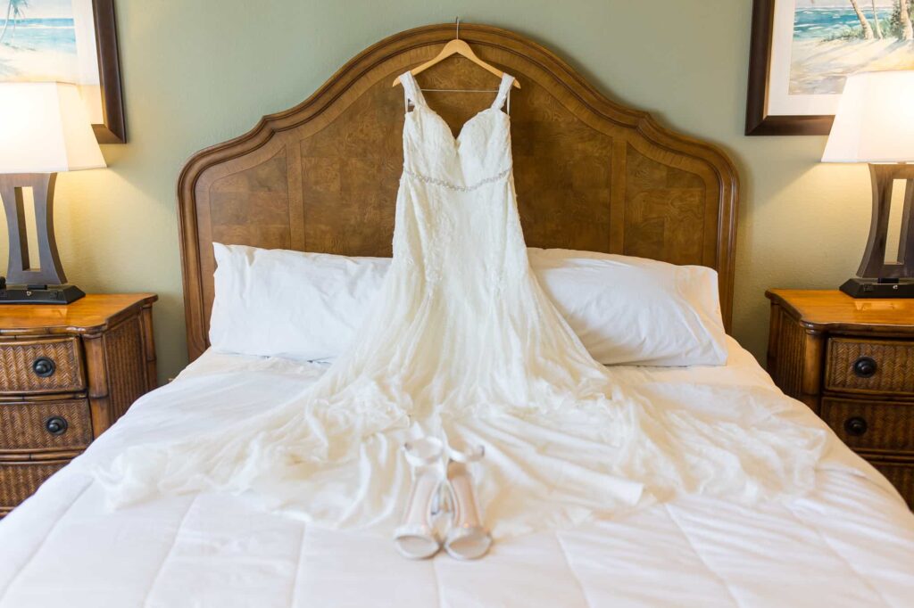 wedding dress hanging on bed at Zachari Dunes