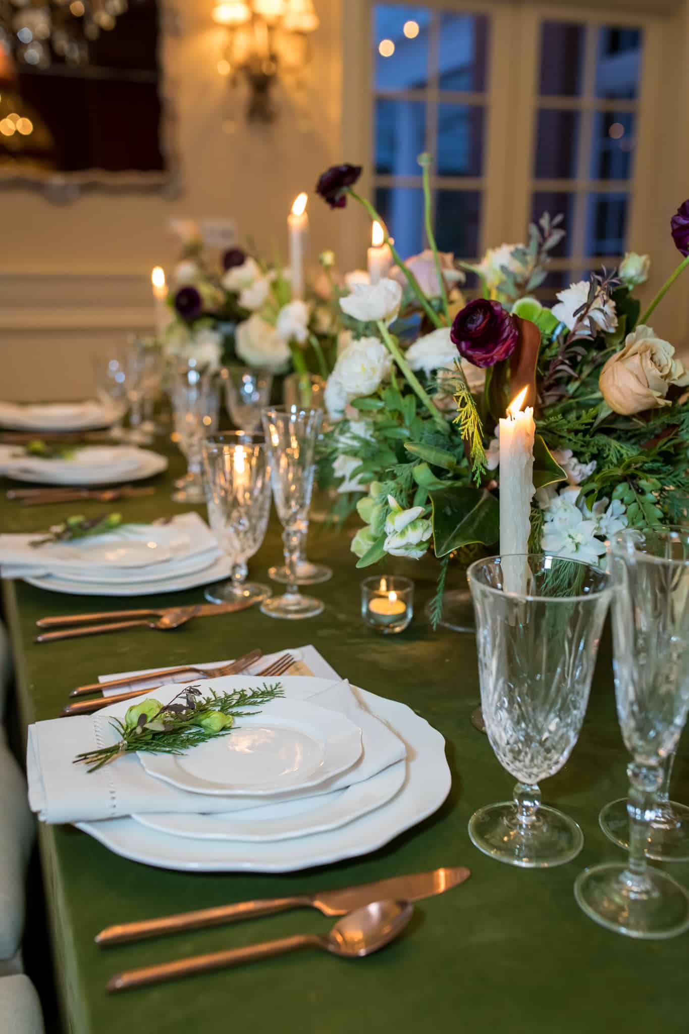 winter wedding ideas and decor with a table setting of white plates, tall candles and elegant floral arrangements