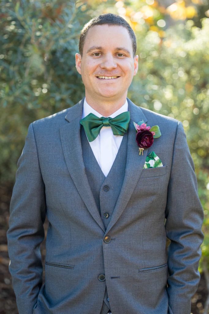 groom with green bow tie and boutonnière