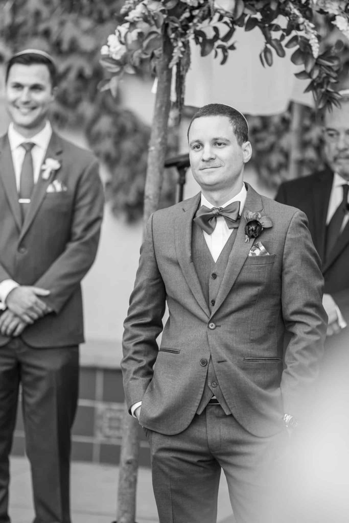groom watching bride walk down the wedding aisle