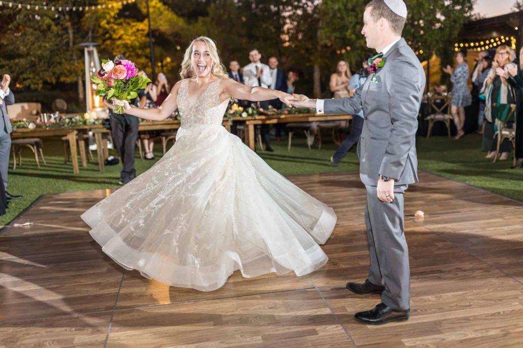 bride and groom twirling at their grand entrance