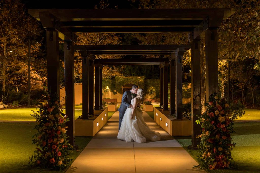 bride and groom kissing at los robles greens at night