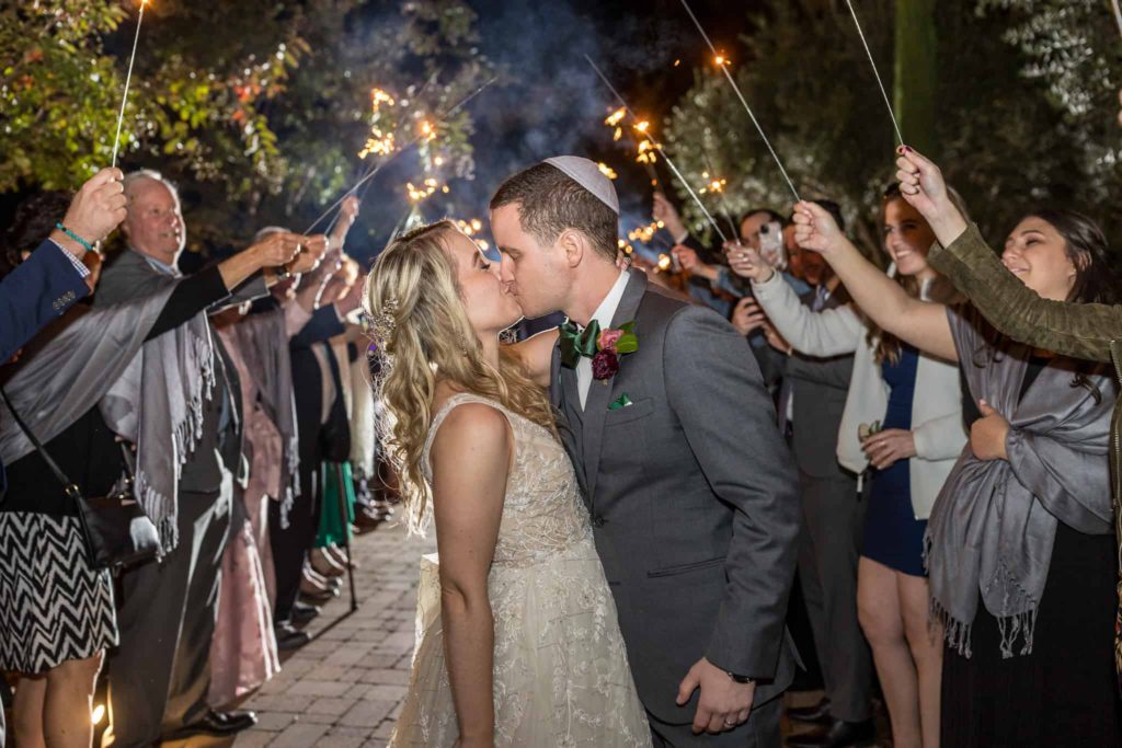 bride and groom kissing at sparkler exit