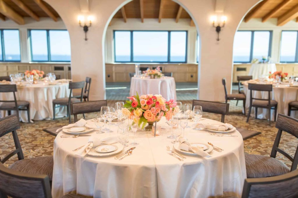 wedding reception space at Cabrillo Pavillion in Santa Barbara with classic white table clothes and pink florals