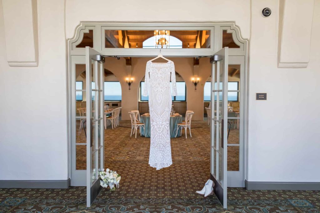 lace wedding dress hanging on a door way in Cabrillo Pavilion