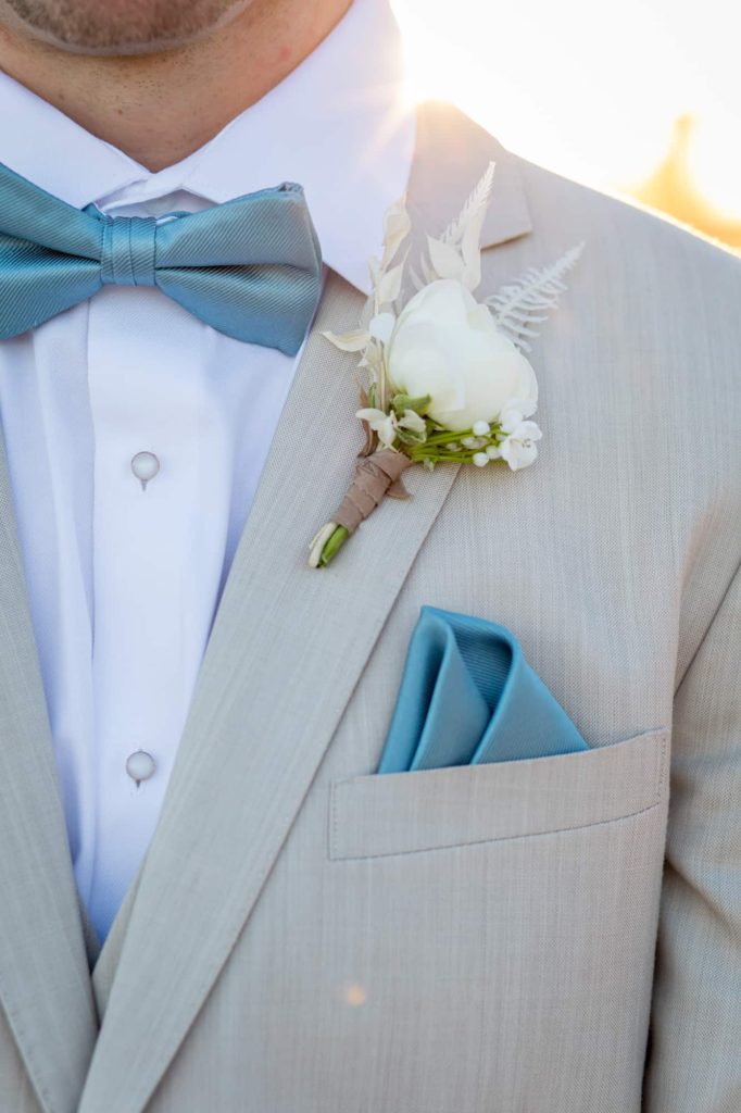 detail shot of grooms white rose boutonnière