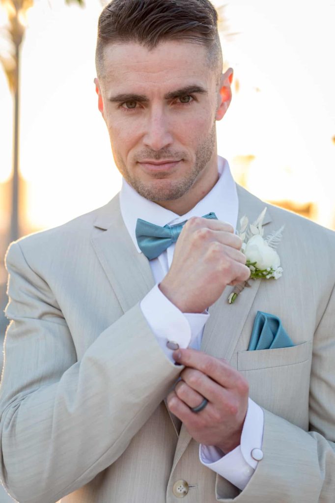 groom touching his cufflinks as he poses or groom portraits