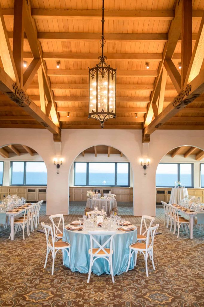 Cabrillo Pavilion reception space with vaulted wood ceilings and arched door ways set up for a beach themed wedding