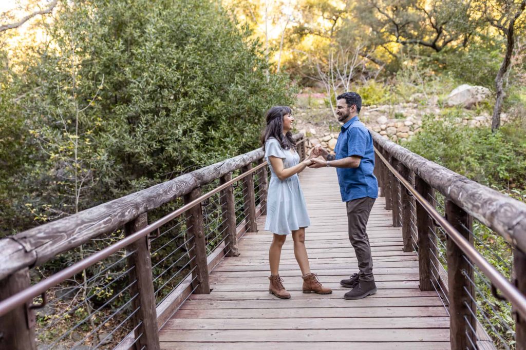 man and woman holding hands together on a bridge in Santa Barbara Botanical Gardens