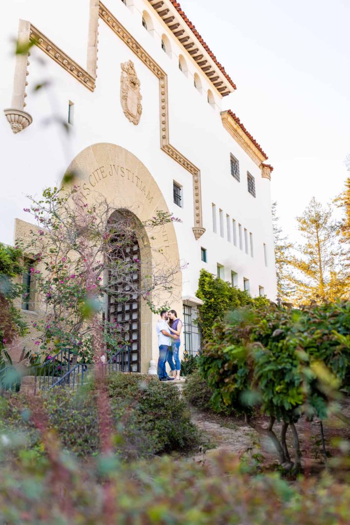engagement photos at Santa Barbara Courthouse, captured by Santa Barbara wedding photographer, with man and woman holding each other in a lush garden