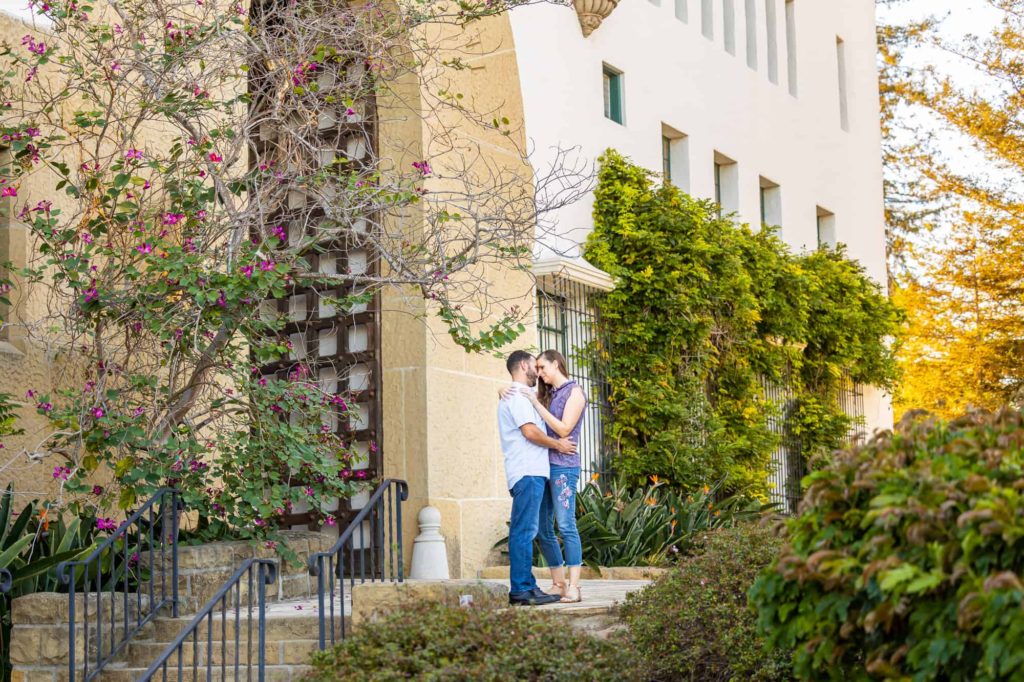 summer engagement photos in Santa Barbara with man and woman embracing each other in the courtyard of Santa Barbara courthouse