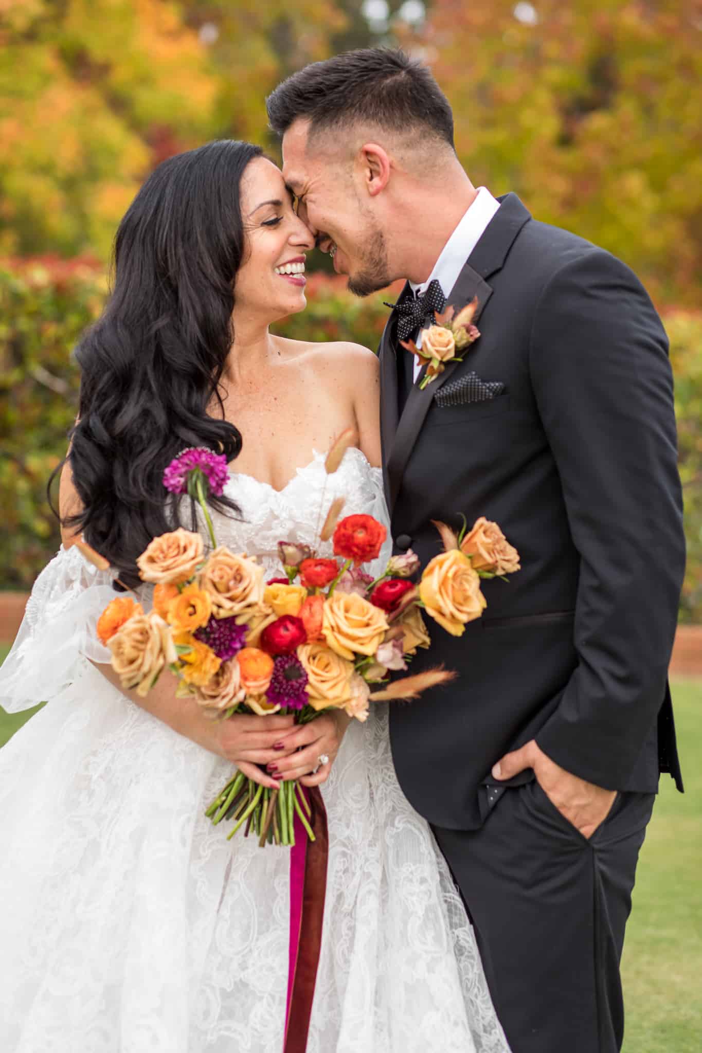 bride and groom laughing as they press their noses together for their fall bridal shoot