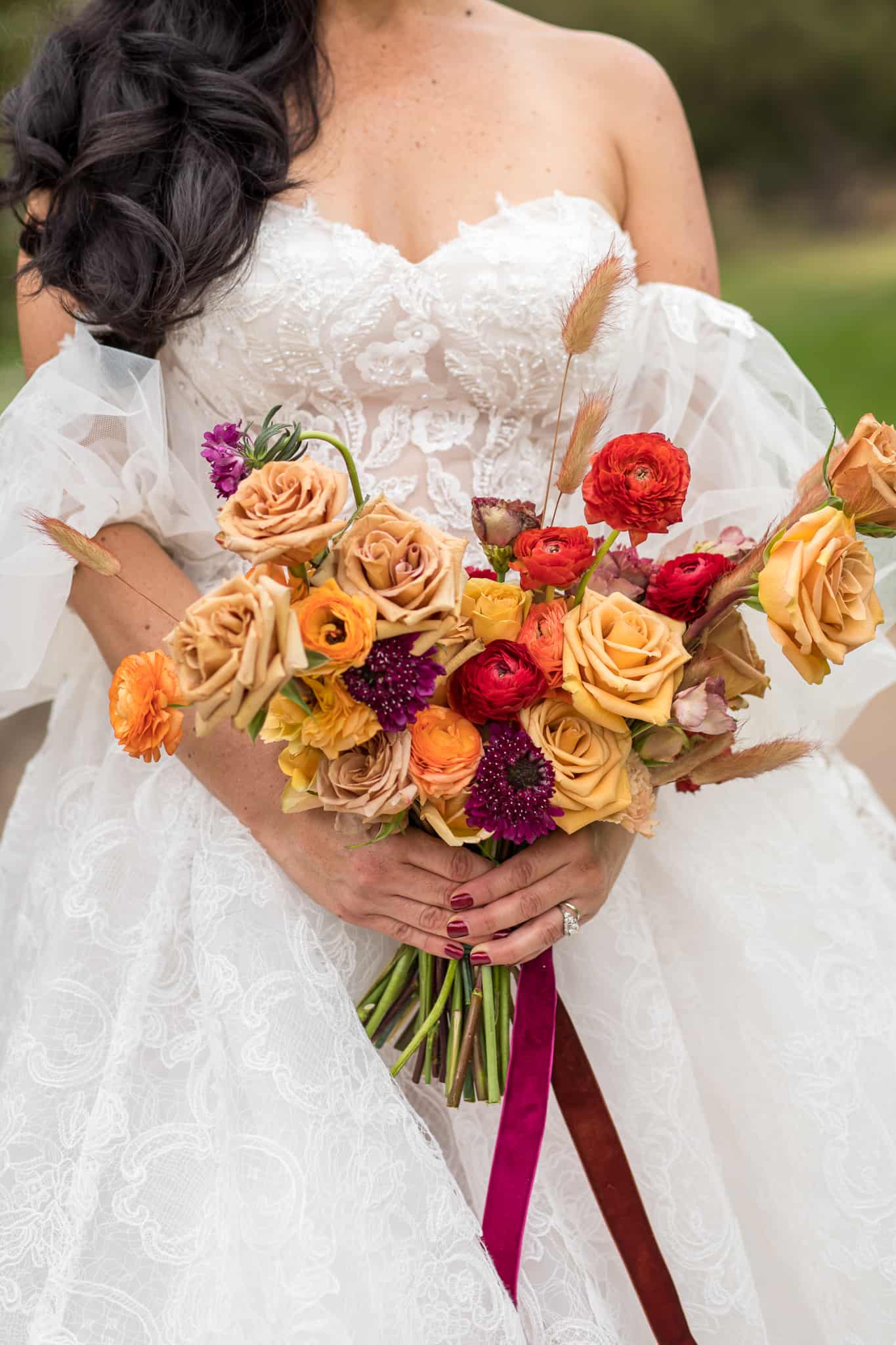 detail shot of bride holding her wedding bouquet with warm fall colors