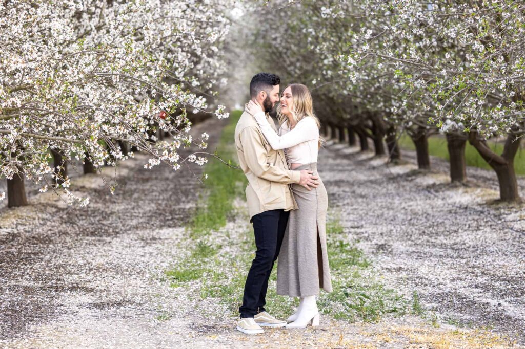 Central Valley California wedding photographer captures engagement photos in a blossoming almond orchard